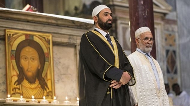 Imame in einer katholischen Kirche vor einer Darstellung von Jesus Christus, der vom Islam