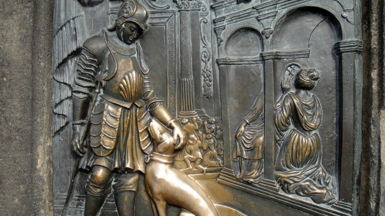 Bronzerelief auf der Karlsbrücke in Prag. Es zeigt im Hintergrund den heiligen Nepomuk, der die Beichte der Königin hört.
