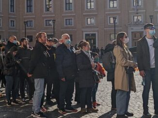 Menschen warten auf Einlaß auf den Petersplatz. Auf dem Platz gilt seit gestern Maskenpflicht, außerhalb auf italienischem Staatsgebiet nicht (bzw. ist Interpretationssache).