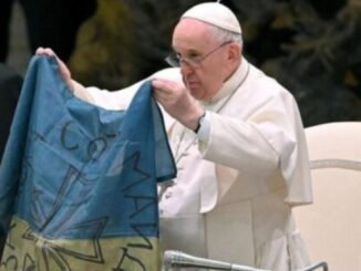 Papst Franziskus mit einer ukrainischen Fahne. Sein Wunsch, als Friedensvermittler aufzutreten, gestaltet sich als schwierig, dennoch hält im zehnten Monat daran fest.