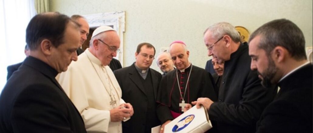 Papst Franziskus läßt sich 2015 von Pater Marko Ivan Rupnik das Logo für das Jahr der Barmherzigkeit zeigen.