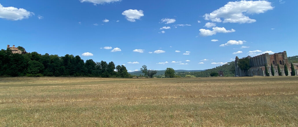 Links der Montesiepi, auf den sich der heilige Galganus zurückzog und 1181 starb, rechts die Ruinen der Zisterzienserabtei Links der Montesiepi, auf den sich der heilige Galganus zurückzog und 1181 starb, rechts die Ruinen der Zisterzienserabtei