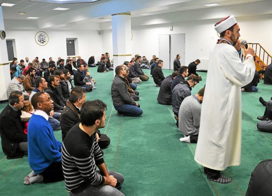 Katholiken und Moslems beim Freitagsgebet in der Moschee. Pfarrer Bigumira im blauen Pullover hinter dem Imam.